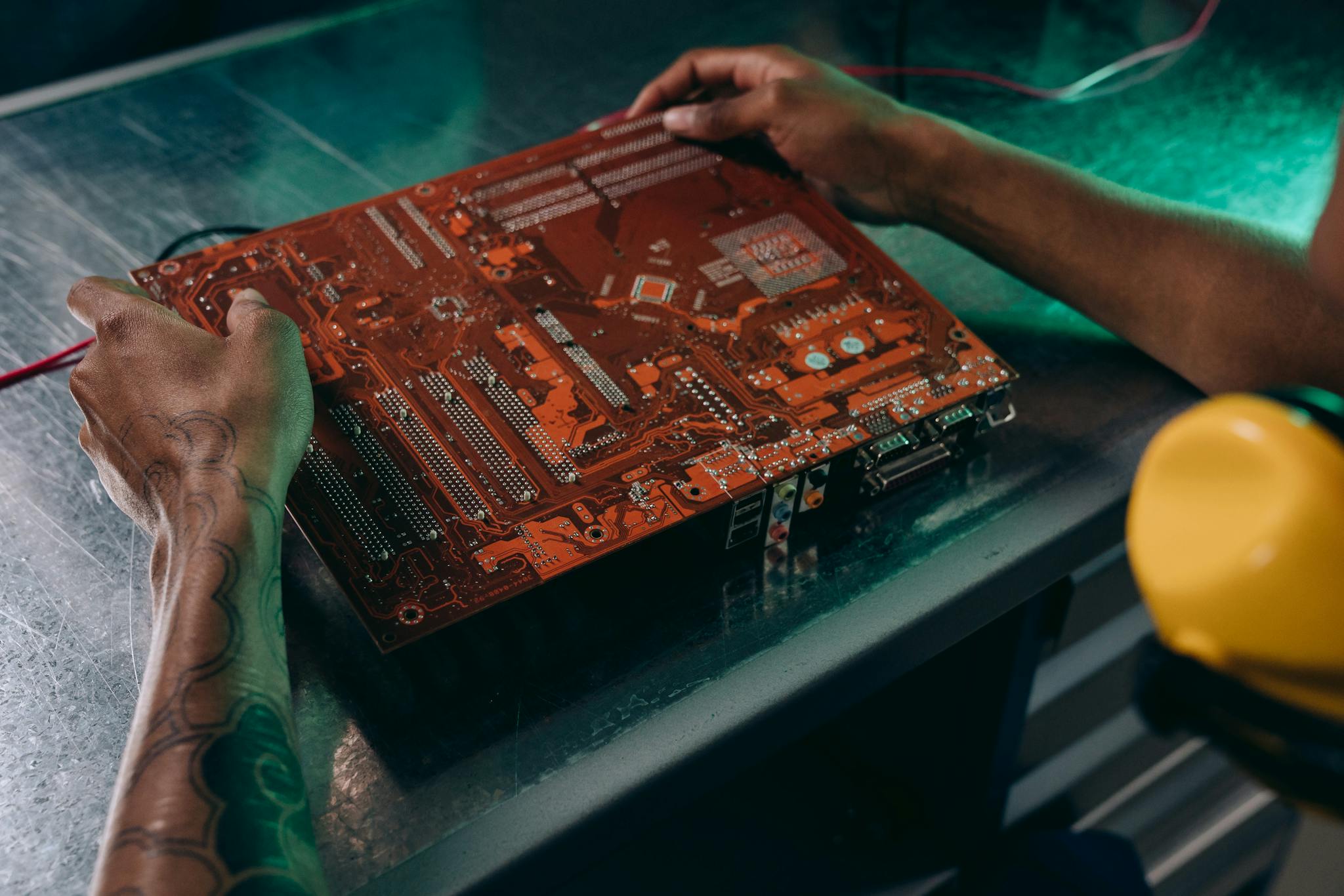 Close-up of a technician working on a circuit board in an industrial setting.